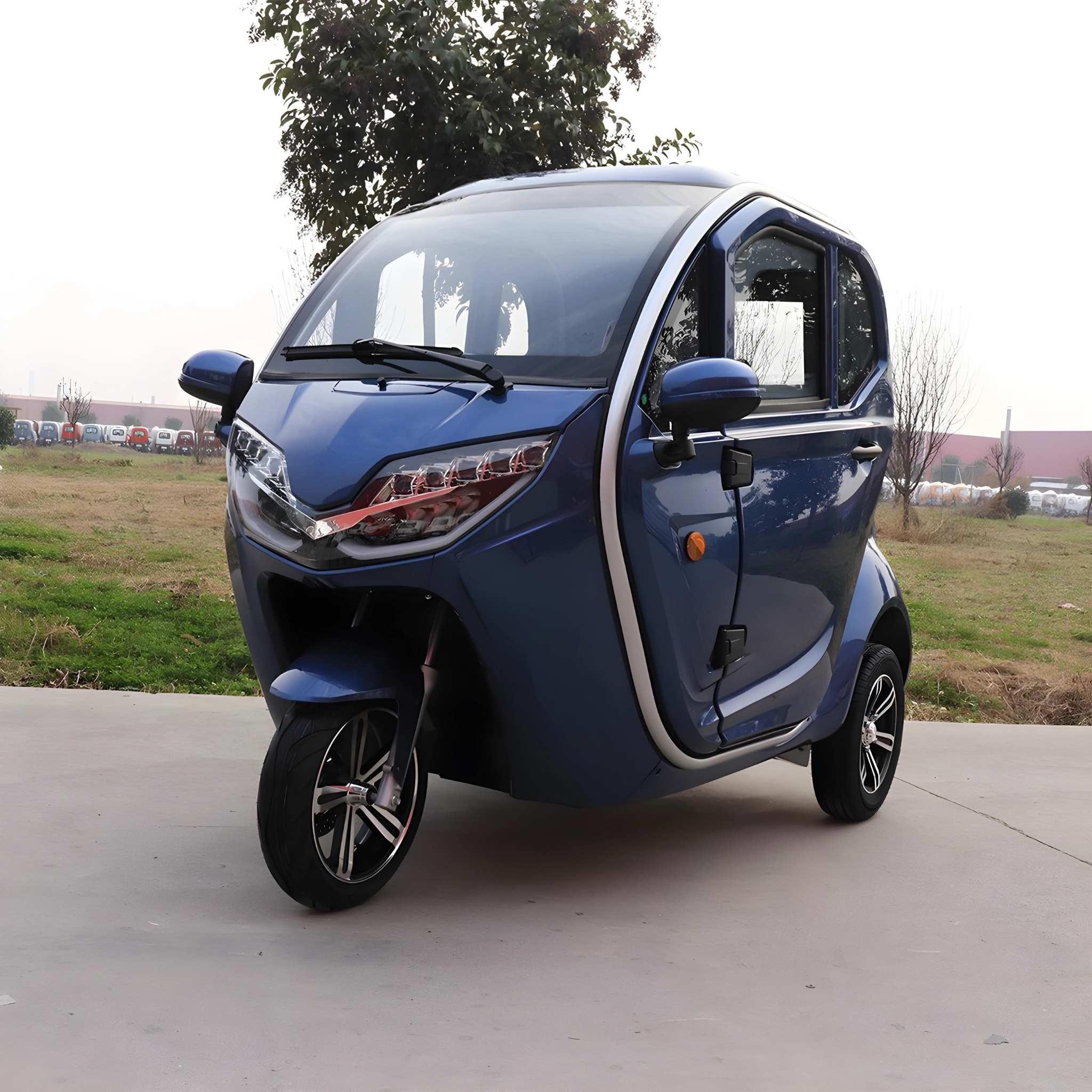 Ein kompakter, blauer EQ-Mobil Kabinenroller Lima Q3 Li 45 / 25 km/h mit Lithium-Akku wird auf dem Bürgersteig zwischen Gras und Bäumen unter Wolken geparkt. Das dreirädrige Elektrofahrzeug verfügt über zwei Vordertüren und eine gewölbte Windschutzscheibe.