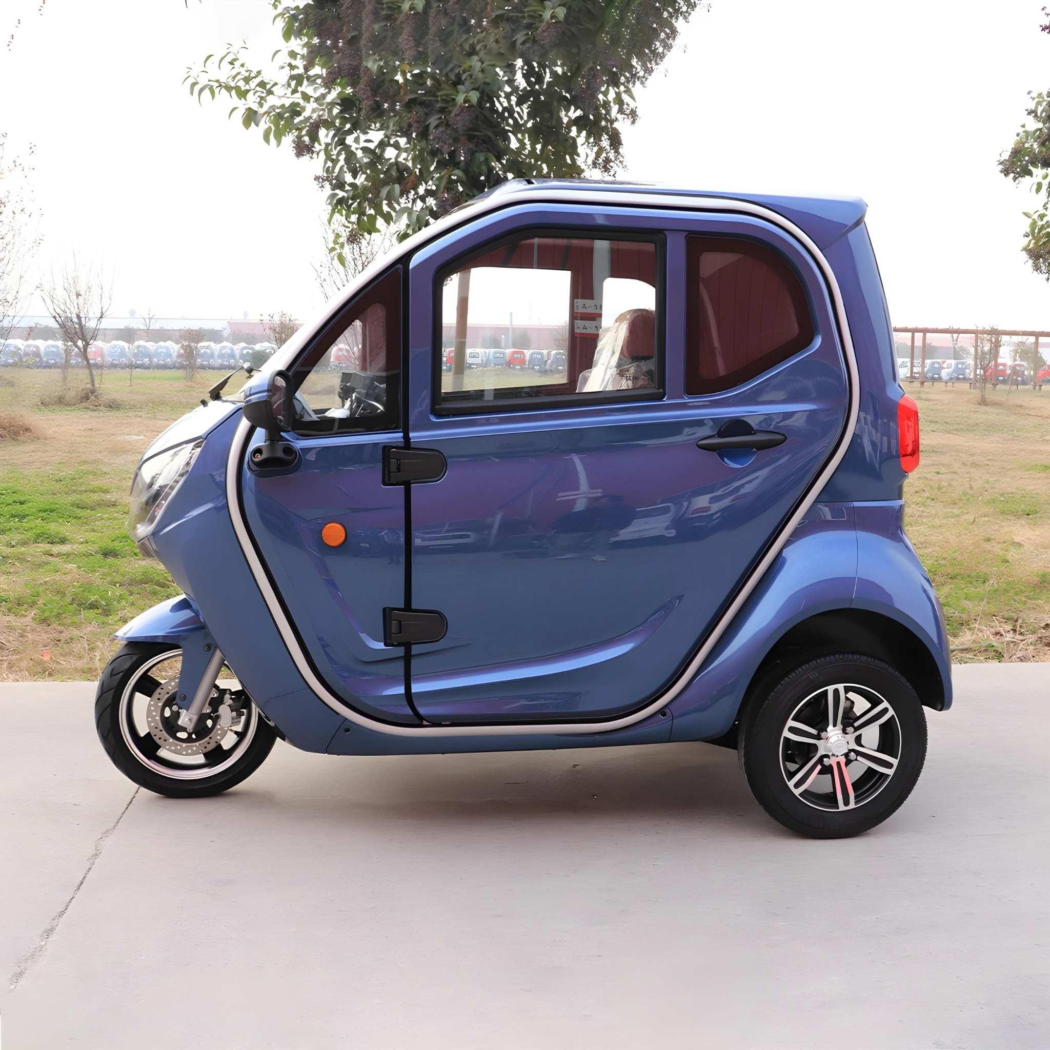 Ein kompakter, blauer EQ-Mobil Kabinenroller Lima Q3 Li 45/25 km/h mit einer Lithium-Batterie steht auf einem gepflasterten Weg zwischen Gras und Bäumen. Das neueste Modell verfügt über große Fenster und ein modernes Design.