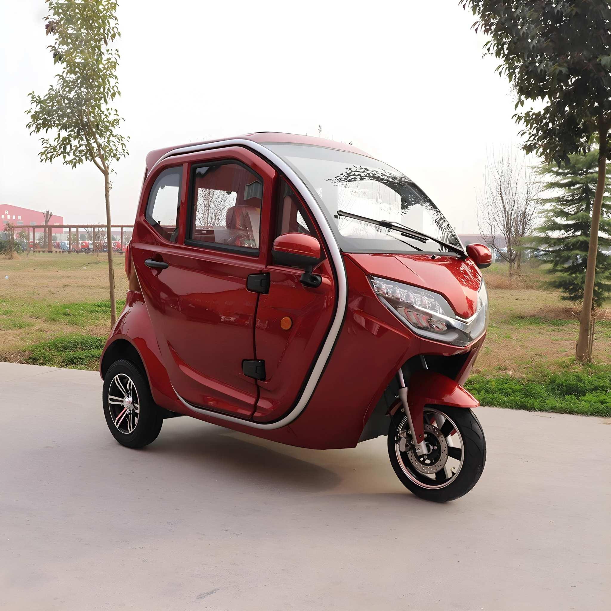 Ein kompakter, roter EQ-Mobil Kabinenroller Lima Q3 Li 45/25 km/h mit Lithium-Batterie steht im Freien auf dem Bürgersteig, umgeben von Gras und Bäumen unter einem teilweise bewölkten Himmel.