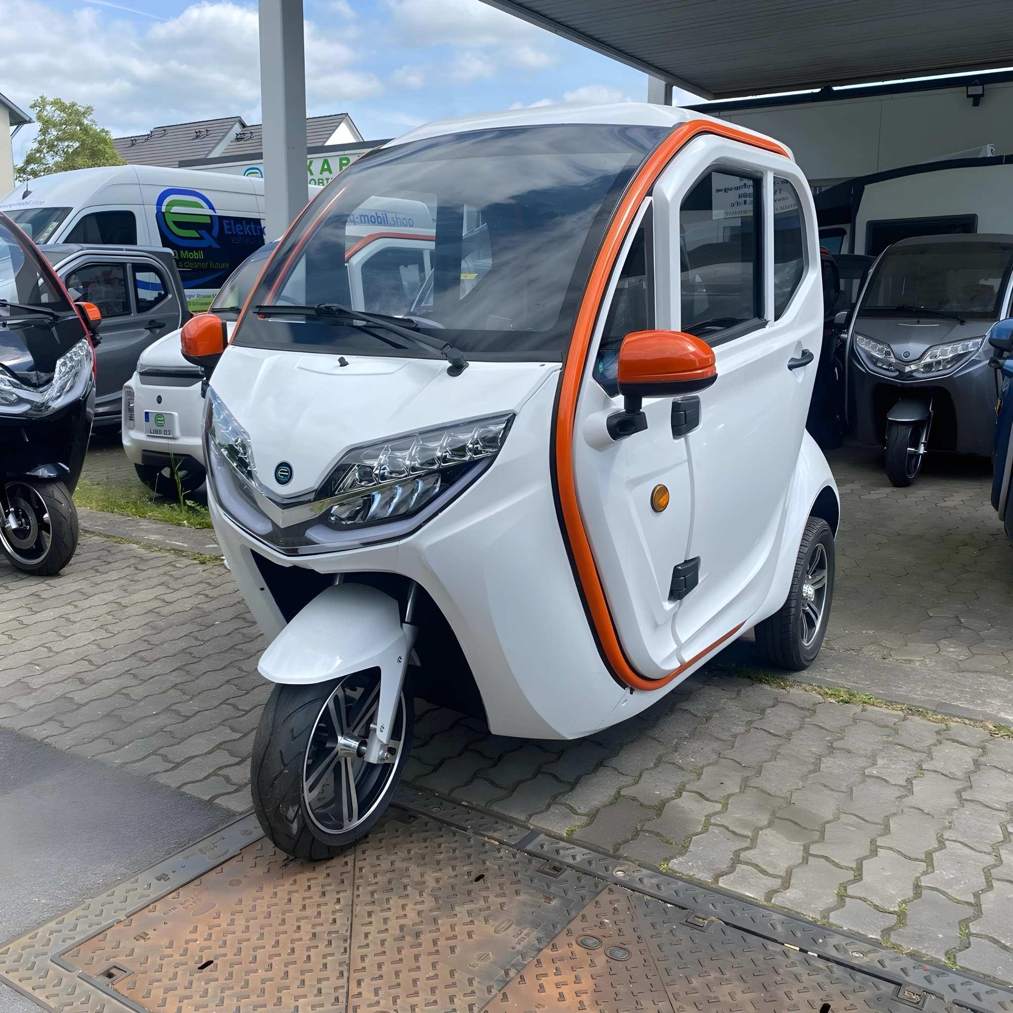 Ein EQ-Mobil Kabinenroller Lima Q3 Li 45 / 25 km/h, aktuelles Modell mit einem Lithium-Akku in weiß und orange, steht auf dem Gehweg in der Nähe eines Autohauses inmitten anderer Kleinfahrzeuge geparkt.