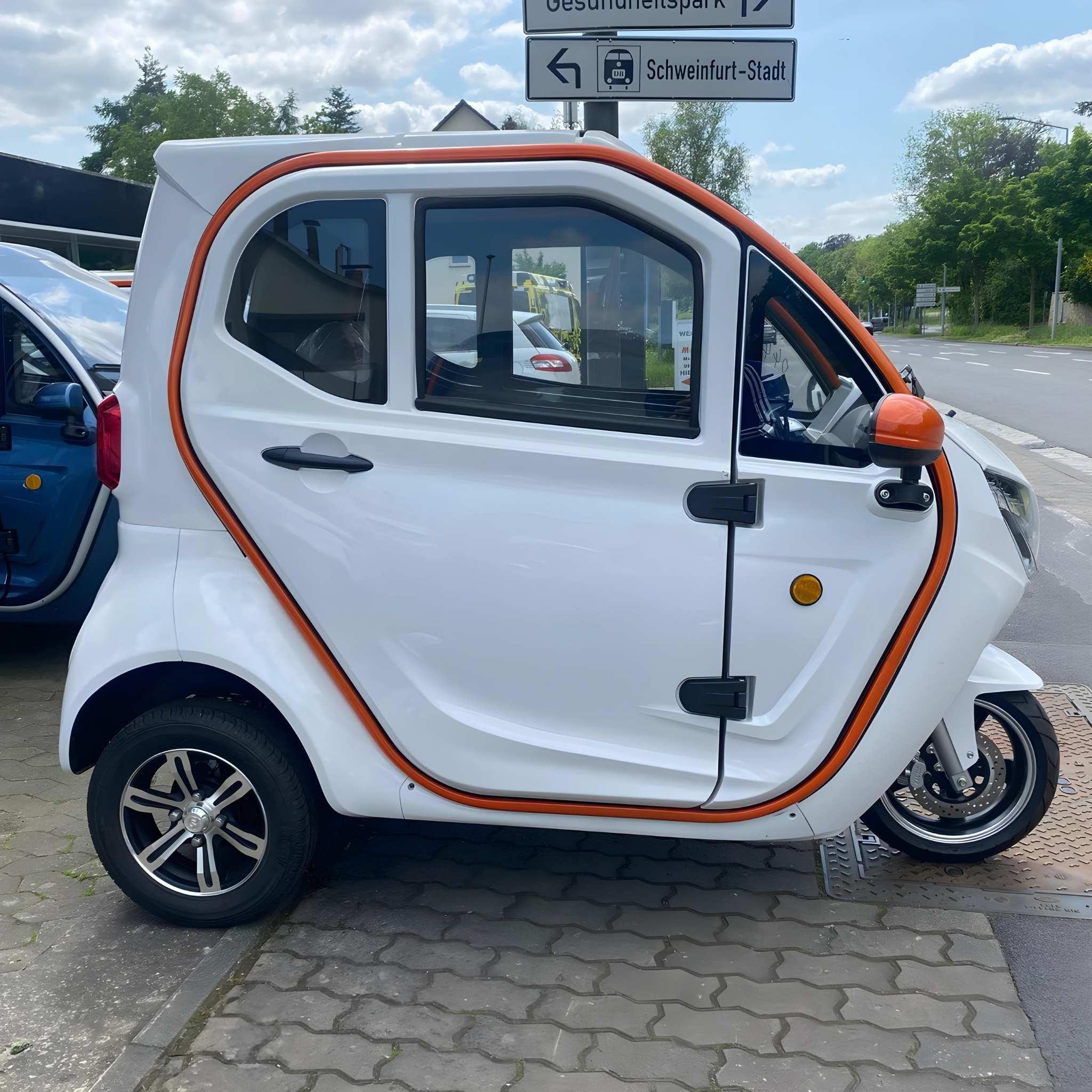 Ein kompakter, weißer EQ-Mobil Kabinenroller Lima Q3 Li 45/25 km/h mit orangefarbener Zierleiste und Lithiumbatterie parkt auf einem Gehweg in einem Vorort in der Nähe eines Straßenschildes, mit Bäumen und Autos im Hintergrund - ideal für effiziente Mobilität in der Stadt.