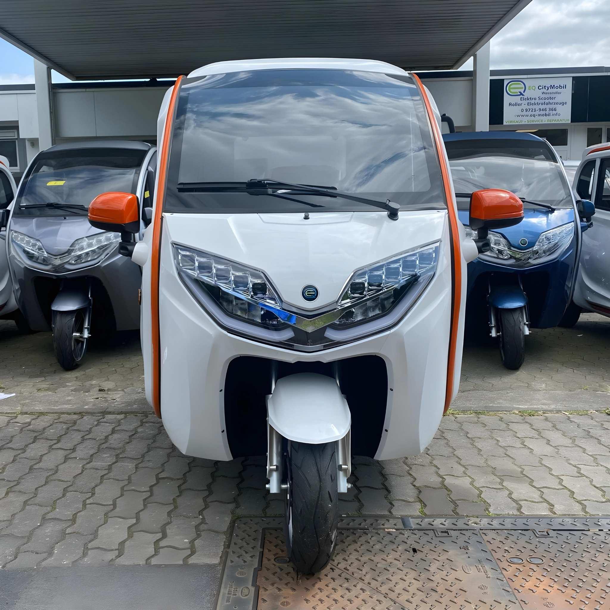 Ein weißer EQ-Mobil Kabinenroller Lima Q3 Li 45 mit Lithiumbatterie und orangefarbenen Akzenten ist auf dem Bürgersteig geparkt und zeigt nach vorne. Weitere EQ-Mobil City Mobil Fahrzeuge in verschiedenen Farben sind auf beiden Seiten im Hintergrund zu sehen.