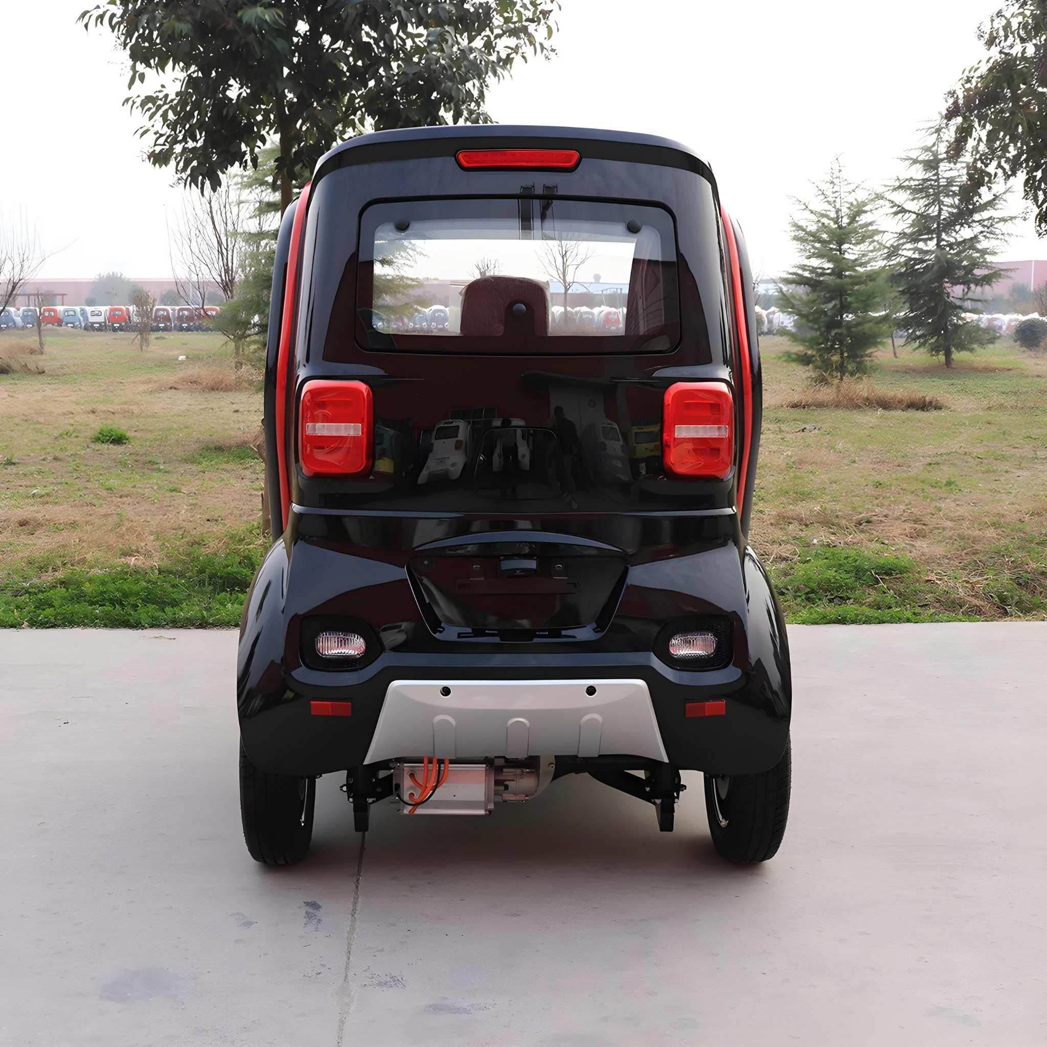 Ein kompaktes, schwarzes EQ-Mobil Kabinenroller Lima Q3 Li 45 / 25 km/h Elektrofahrzeug ist auf Beton mit Gras und Bäumen unter einem bewölkten Himmel geparkt und zeigt rote Akzente und Rückleuchten. Angetrieben von einem Lithium Akku - aktuelles Modell.