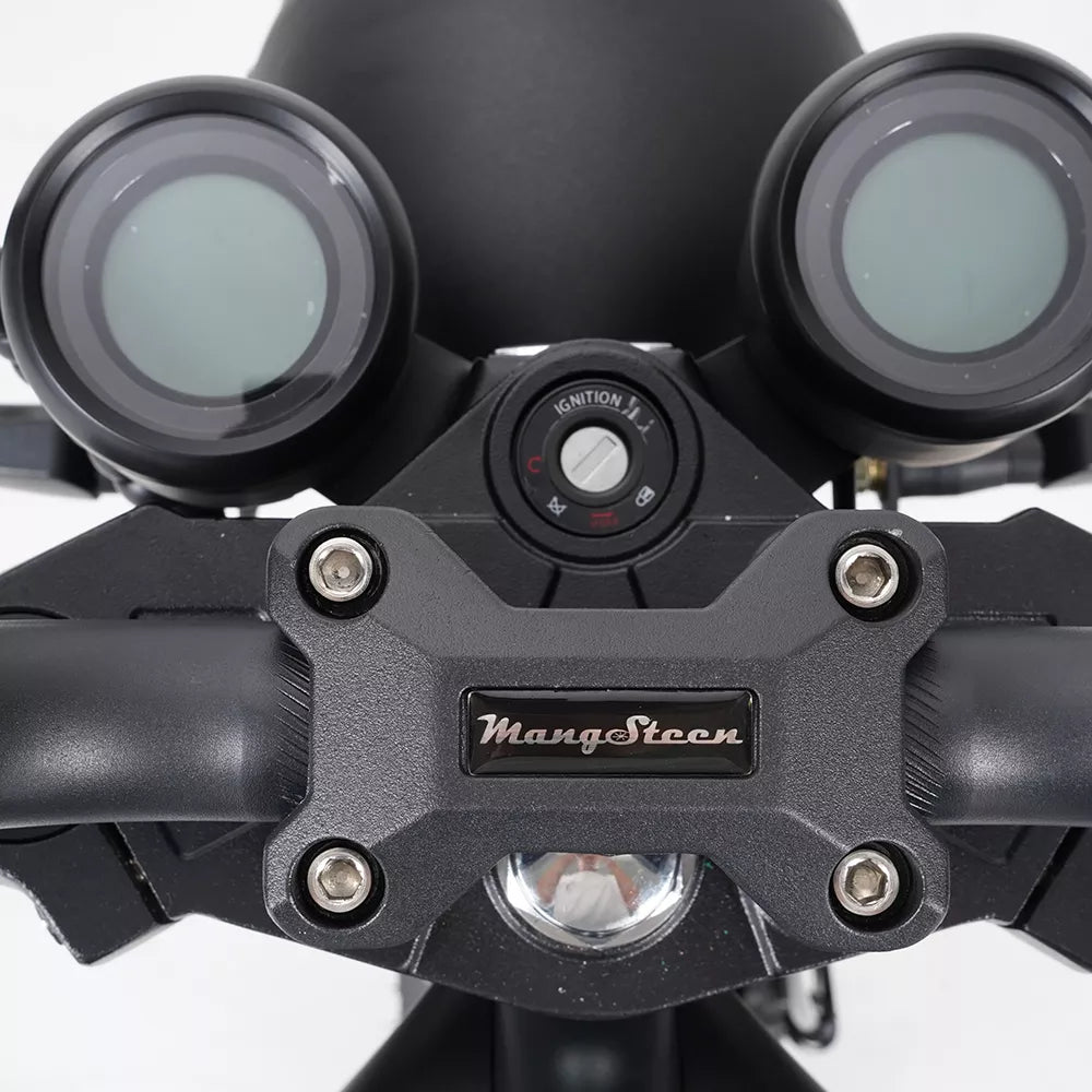 Nahaufnahme des Armaturenbretts des Mangosteen M1P Citycoco E-Choppers mit zwei runden Anzeigen, zentraler Zündung, schlanker Lenkerklemme und fortschrittlichem 30 Ah Lithium-Ionen-Akku. Das Modell 26 erreicht eine Geschwindigkeit von bis zu 45 km/h.