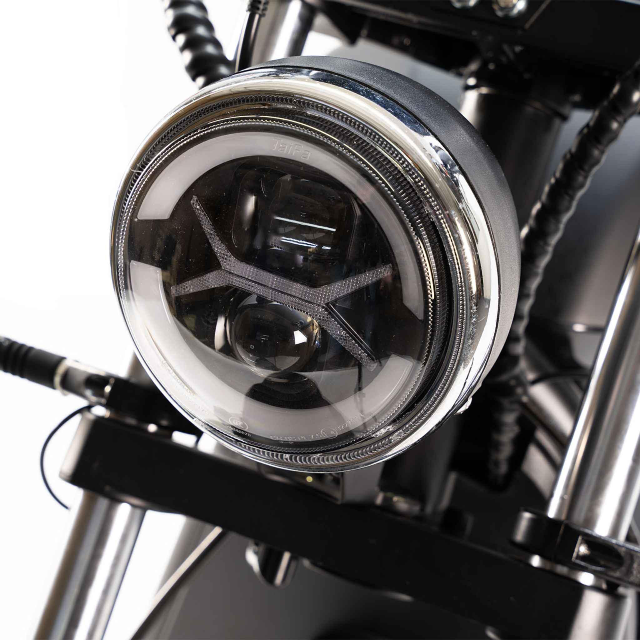 Nahaufnahme des City Twister NEU - E-Choppers: CityTwister 6.0 MAX DUO's runder LED-Scheinwerfer mit klarer Linse und schwarzem Gehäuse, montiert zwischen Gabelrohren, mit detaillierter Verkabelung, angetrieben von einem robusten 4000W Motor. Modell 2026.