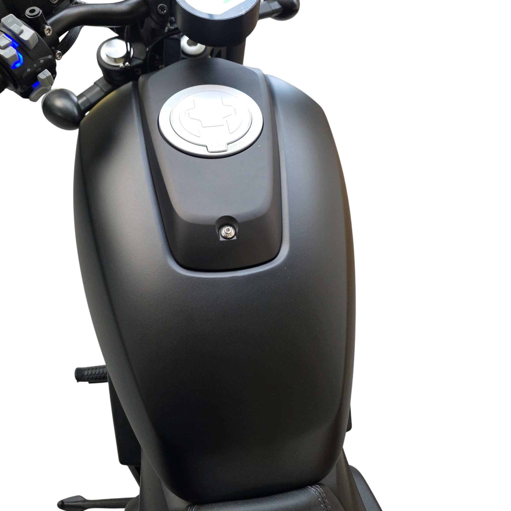 Nahaufnahme des Black-X Limited Edition - Dein Elektromotorrad für echte Individualisten von E.F.O.: silberner Tankdeckel, ein Teil des Lenkers und der Sitz sind auf weißem Hintergrund zu sehen.