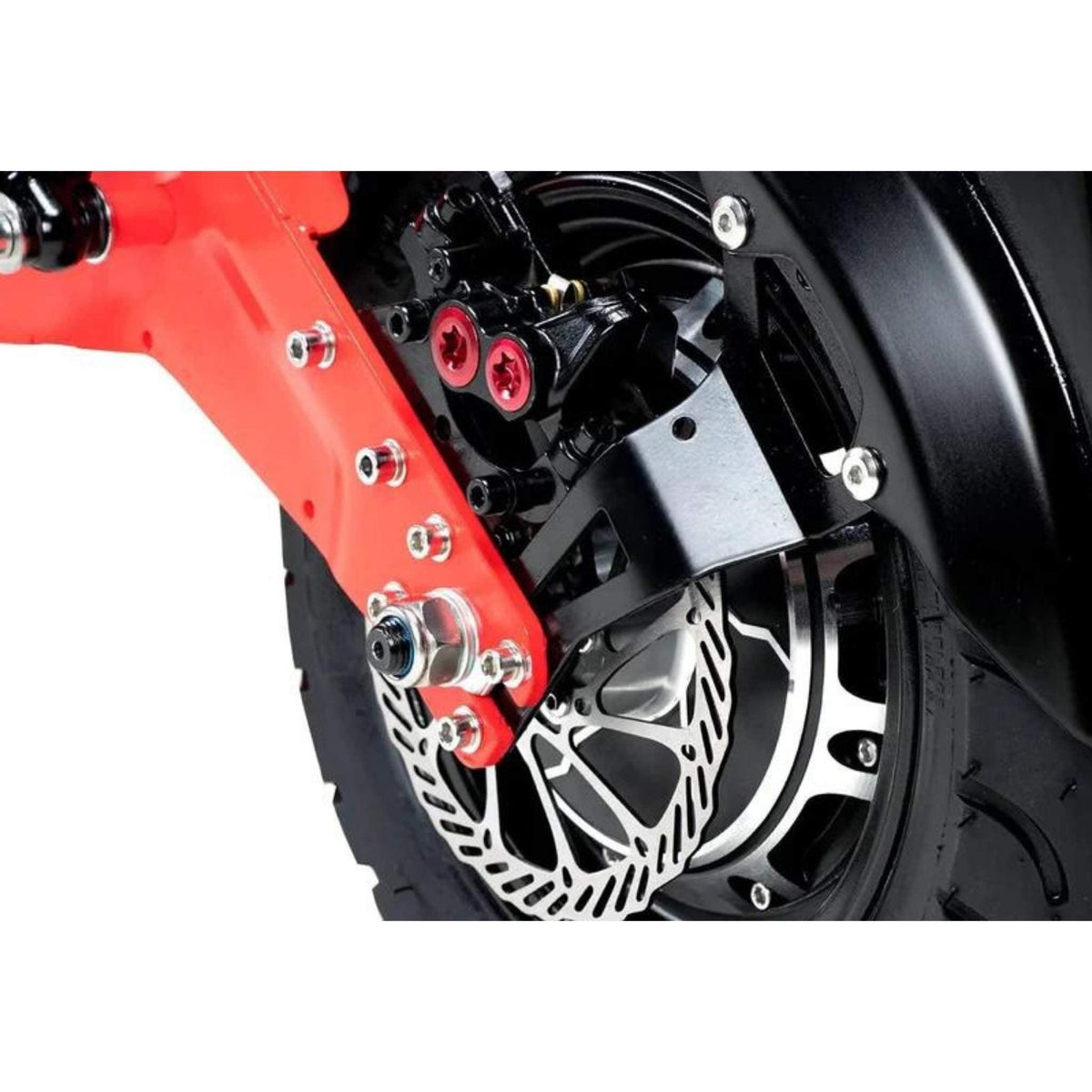 Nahaufnahme des Hinterrads des Wandler K/E 45 km/h mit Sitz und Straßenzulassung E-Rollers / E-Scooter von Wandler, mit Scheiberbremse, Bremssattel, Reifen und einem Ausschnitt des roten Federarms – ein Beispiel für die Präzisionstechnik, die moderne elektrische Stadtmobilitätslösungen von Wandler auszeichnet.