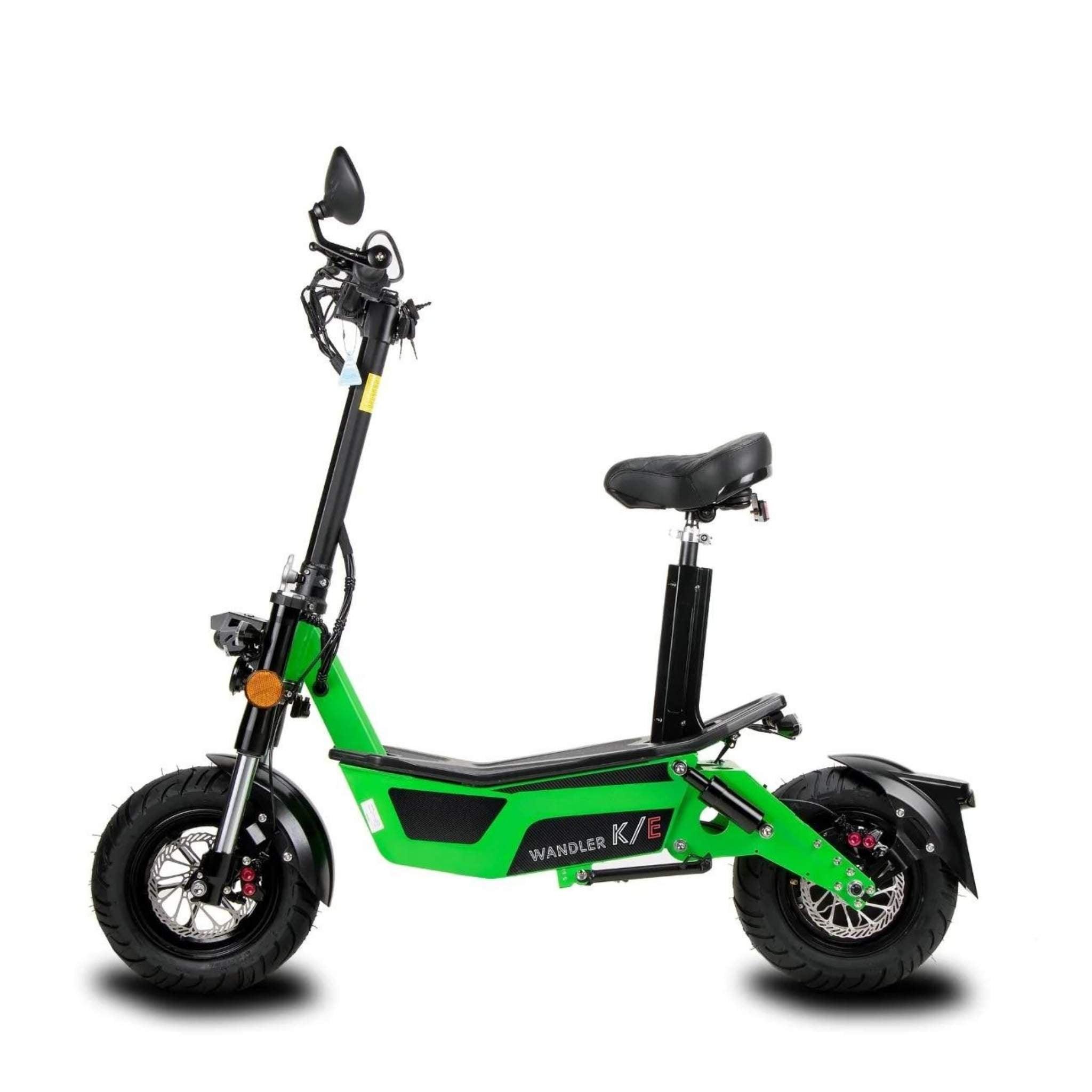 Der Wandler E-Roller / E-Scooter K/E 45 km/h, neues Modell 2025 mit Sitz und Straßenzulassung, hat eine grüne Karosserie, einen schwarzen Sitz, dicke Reifen, einen Rückspiegel am Lenker und eine sichtbare Federung - perfekt für stilvolle, umweltfreundliche Fahrten.