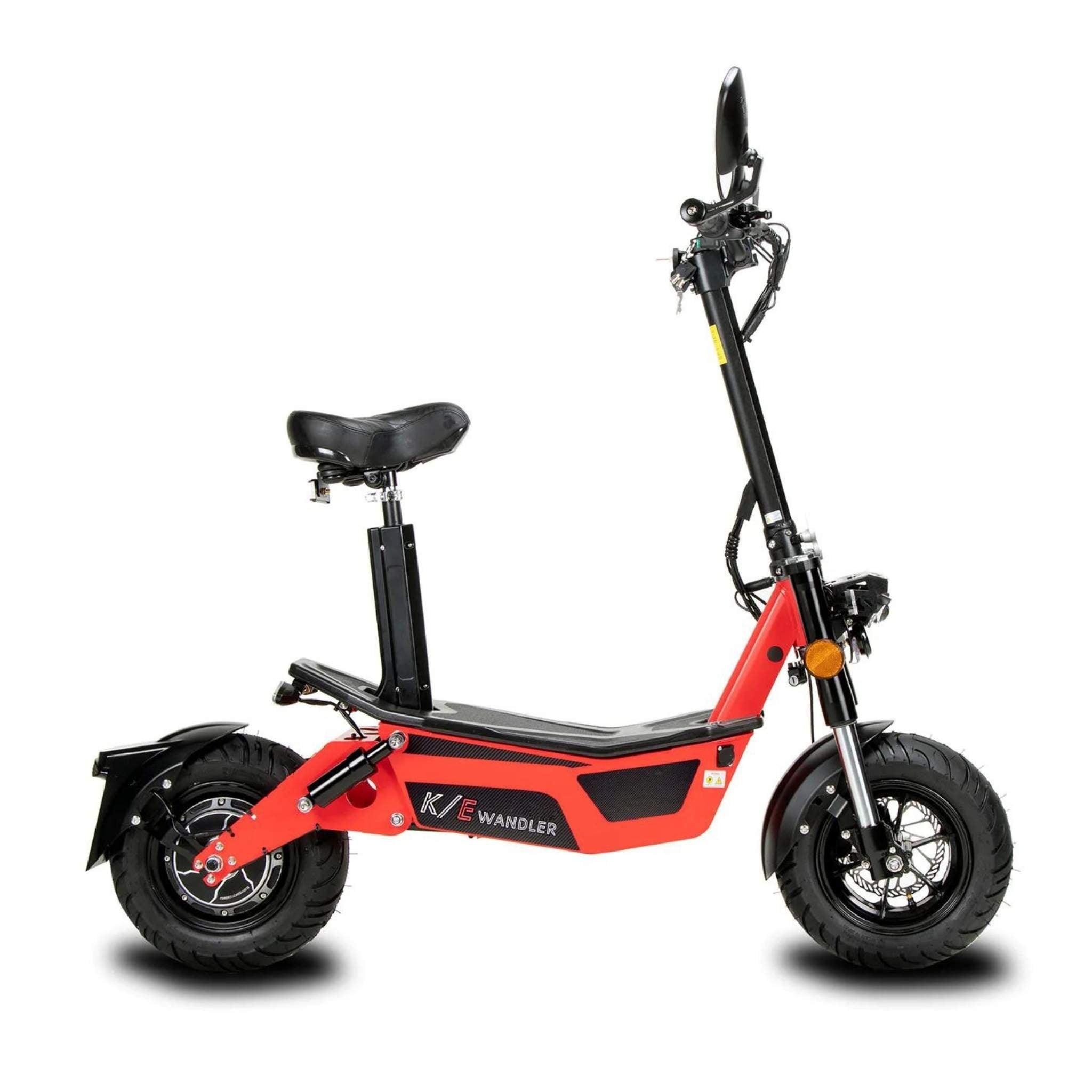 Der Wandler E-Roller/E-Scooter K/E (2025) in Rot und Schwarz, mit Sitz, dicken Reifen, Scheinwerfer und Lenker, wird von der Seite auf weißem Hintergrund gezeigt. Das Wandler-Logo erscheint auf dem Rahmen dieses stilvollen, straßenzugelassenen Modells.