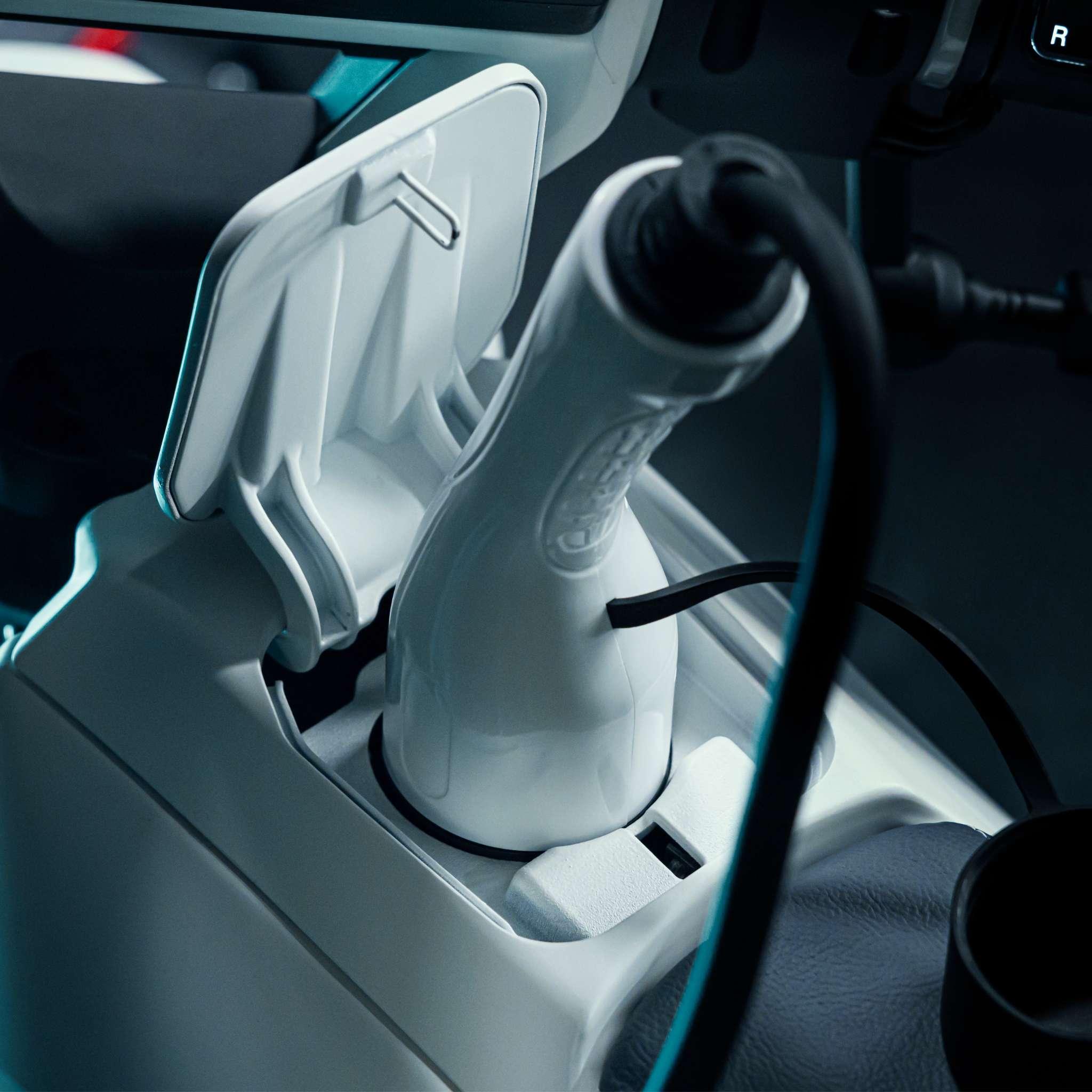 Nahaufnahme eines NAXEON E-Motorrad Naxeon I AM. PRO (Copy) mit eingestecktem Kabel, wobei der Anschlussbereich und Details im Fahrzeuginneren hervorgehoben werden.