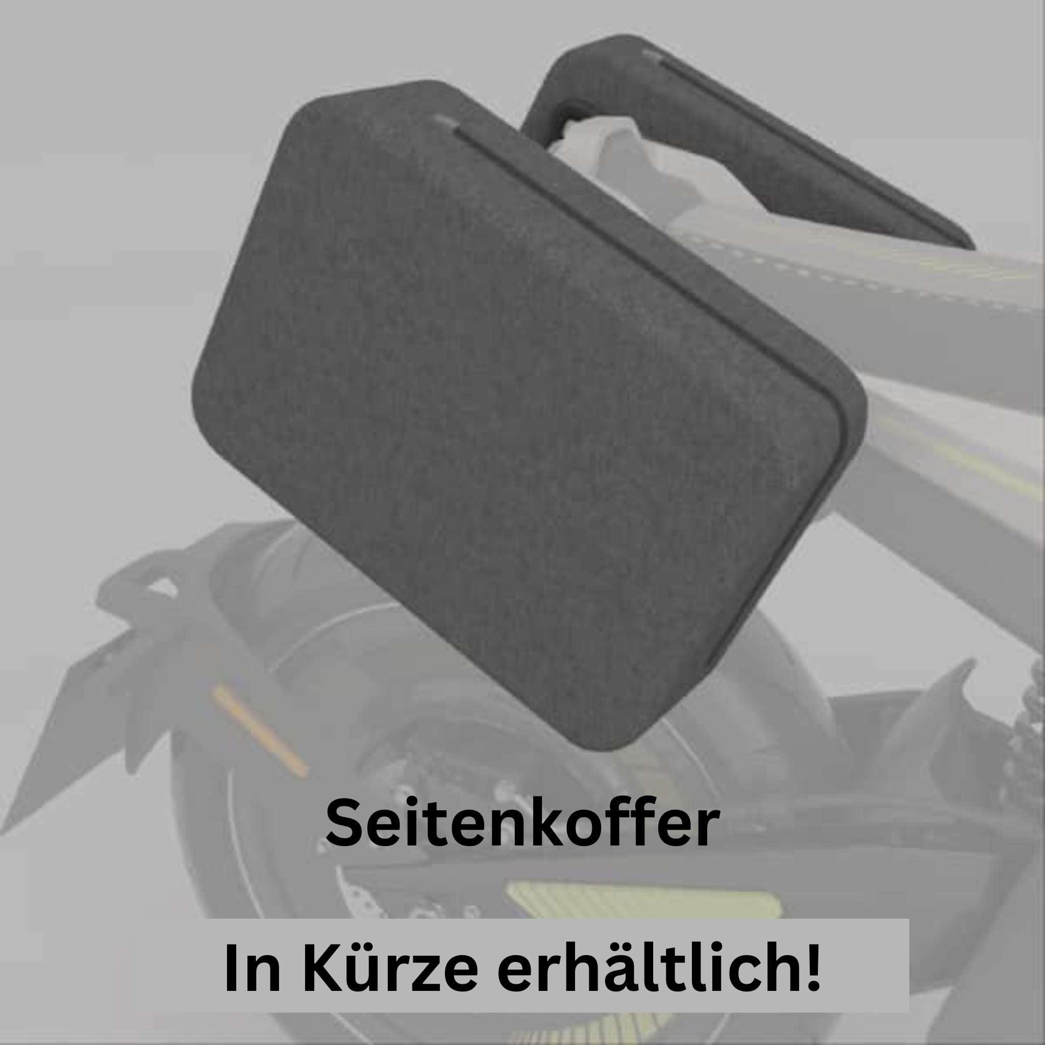 Eine Nahaufnahme eines NAXEON E-Motorrads Naxeon I AM. PRO (Kopie) mit einem dunkelgrauen Seitenkasten über dem Hinterrad. Deutscher Text: Seitenkoffer In Kürze erhältlich! (Seitenkoffer in Kürze erhältlich!). Abgebildet mit Naxeon I-AM Pro Zubehör.