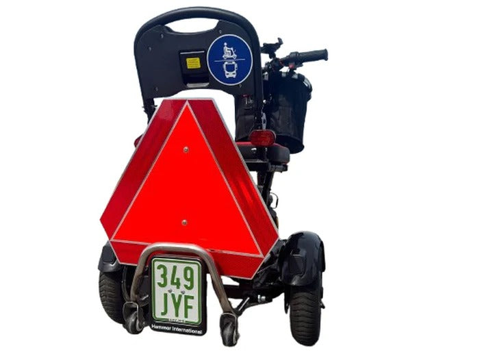 Rückansicht eines SONS OF ELECTRICITY Mobot Krankenfahrstuhl / Seniorenmobil 15 km/h - faltbar, leicht & mit Straßenzulassung, mit rotem reflektierendem Dreieck, blauem Erreichbarkeitszeichen und Nummernschild 349 JYF auf weißem Hintergrund.