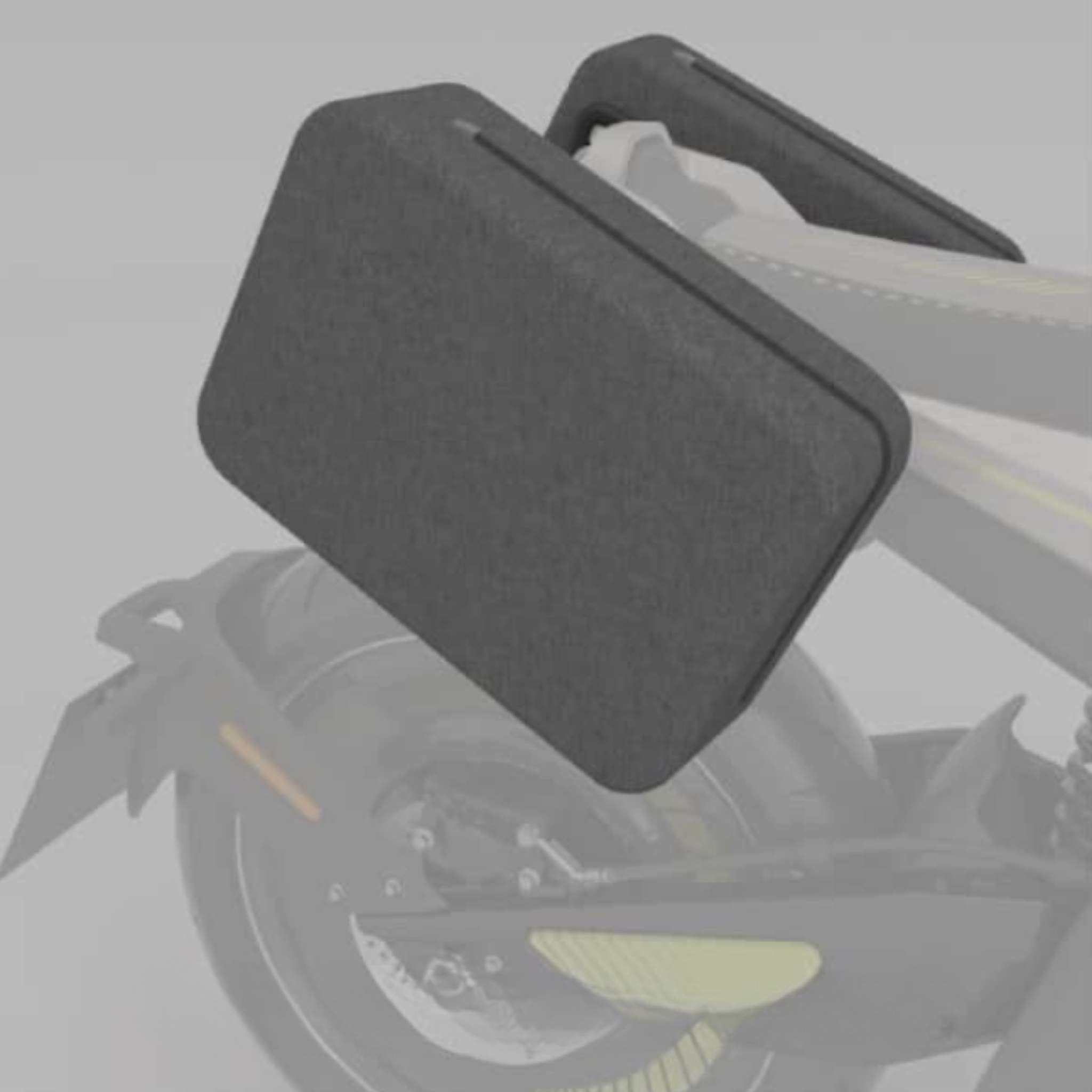 Eine Nahaufnahme eines NAXEON Elektro Motorrad Naxeon I AM zeigt eine große, rechteckige graue Seitentasche/Seitenkoffer inkl. Halterung über dem Hinterrad, mit verblasstem Hintergrund und Details, die die schlanke Satteltasche hervorheben.