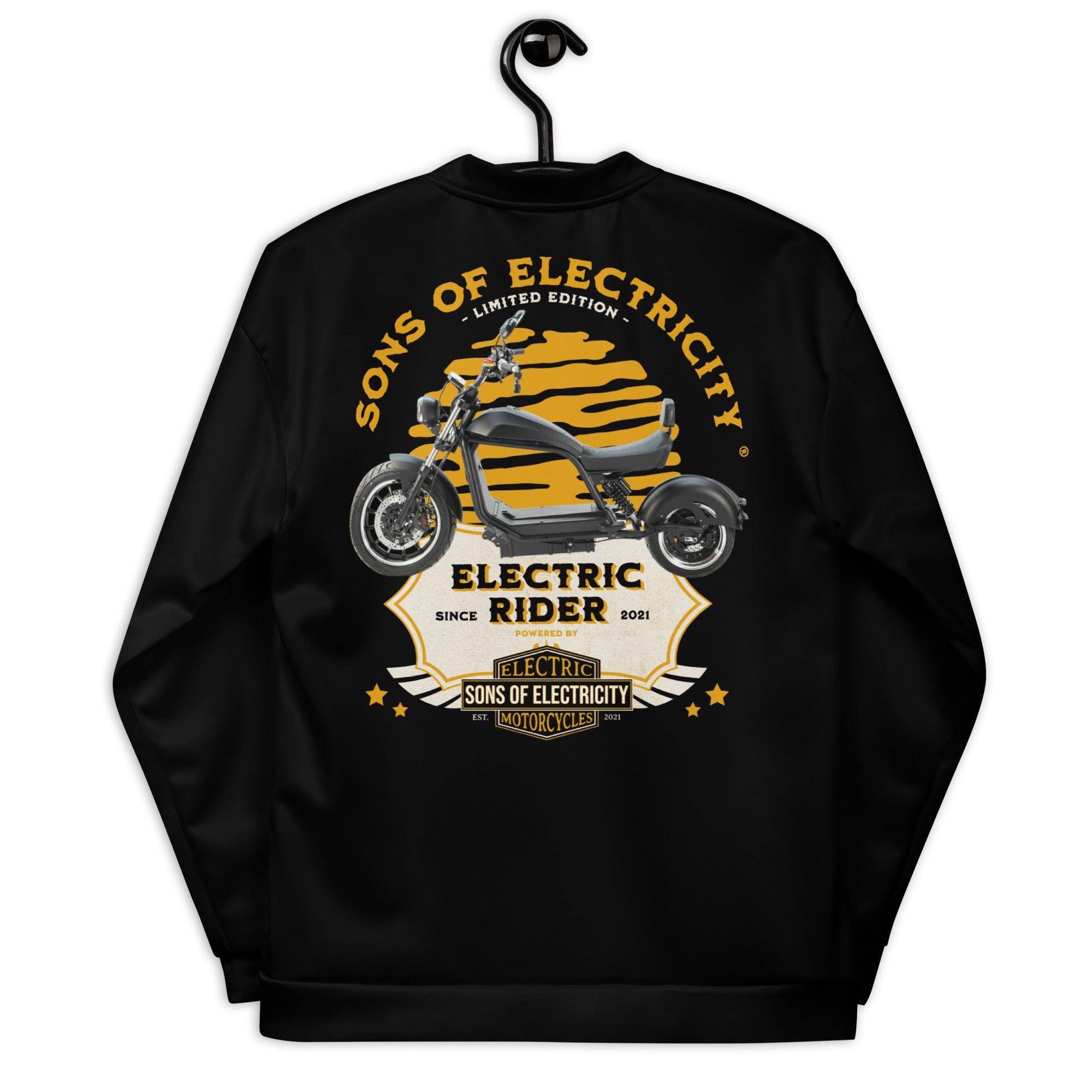 An einem Haken hängt eine schwarze SONS OF ELECTRICITY Premium E-Chopper (2) Bomberjacke mit einer Elektromotorrad-Grafik, einem fetten gelb-weißen "SONS OF ELECTRICITY"- und "Electric Rider Limited Edition"-Text sowie Stern-Akzenten.