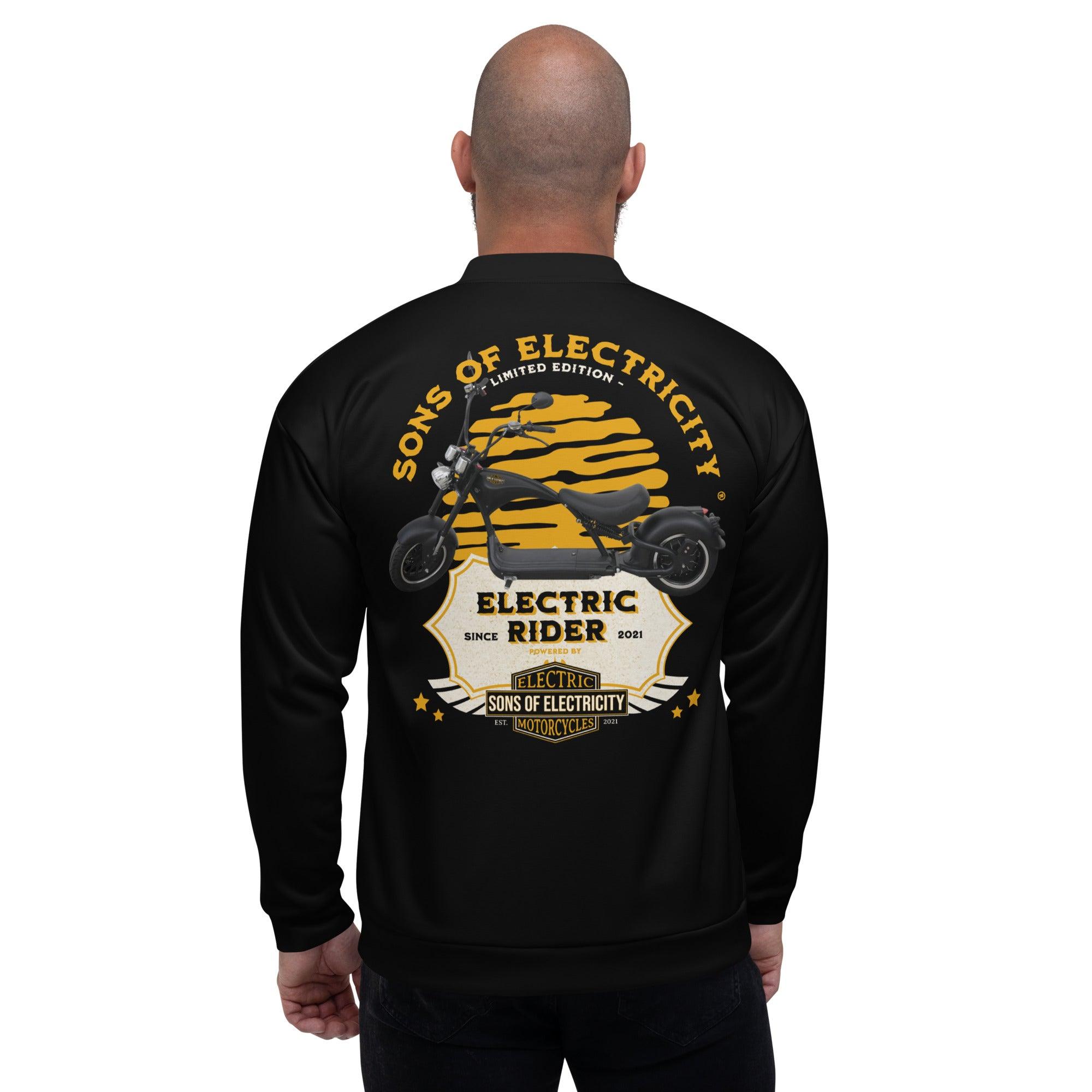 Ein Mann mit Glatze trägt die SONS OF ELECTRICITY Premium E-Chopper (1) Bomberjacke mit einer Motorradgrafik und dem Text "Electric Rider Limited Edition, Since 2021" auf der Rückseite.
