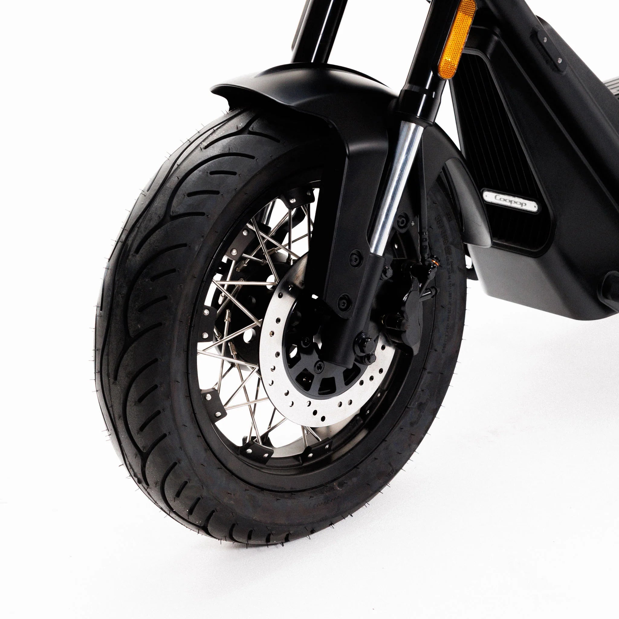Nahaufnahme des schwarzen Vorderrads des Coopop Bobber mit Scheibenbremse und Speichenfelge vor weißem Hintergrund – ein Blick auf Coopops stärksten E-Chopper seiner Klasse (45 km/h, L1e), geräuschlos und leistungsstark.