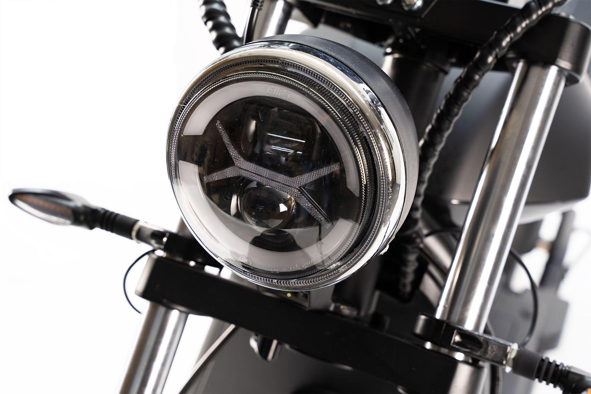 Nahaufnahme des City Twister NEU - E-Choppers: Der runde LED-Scheinwerfer, die Gabelrohre und die Blinker des CityTwister 6.0 MAX DUO, die den leistungsstarken 4000-Watt-Motor hervorheben; Modell 2026 auf weißem Hintergrund.