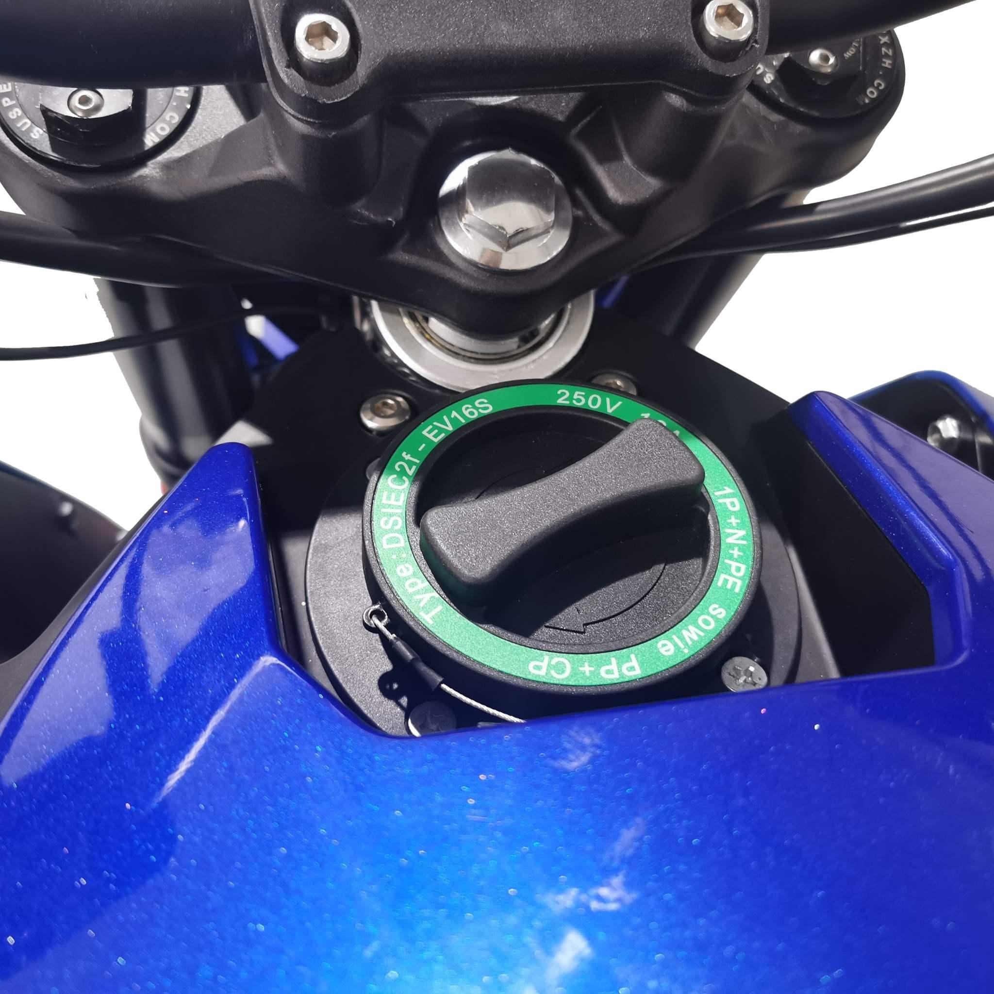 Nahaufnahme des Tankdeckels des Tinbot E-Motorrad TB-RS1 120 km/h (neues Modell) in Grün und Schwarz mit weißer Schrift vor blauem Metallic-Finish; darüber sind der Lenker und das Armaturenbrett zu sehen. Marke: Tinbot.