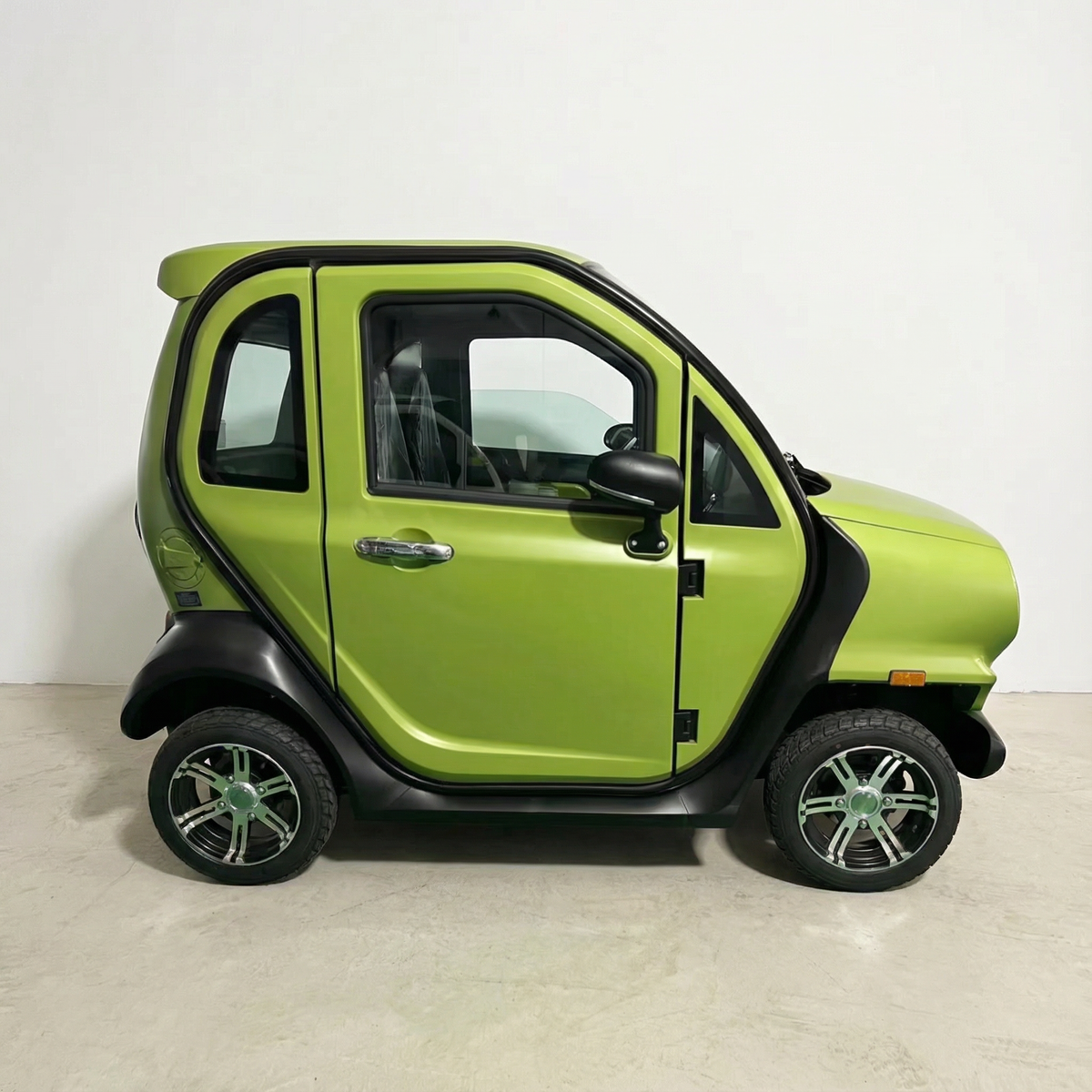 Ein kompakter, umweltfreundlicher City Twister Luqi EV300 Pro Kabinenroller (Modell 2026) mit zwei Türen und eleganter schwarzer Zierleiste steht in einem Innenraum vor einer schlichten weißen Wand, von der Seite betrachtet – ein ideales Elektrofahrzeug mit einer Höchstgeschwindigkeit von 45 km/h für den städtischen Alltag, bei jedem Wetter.
