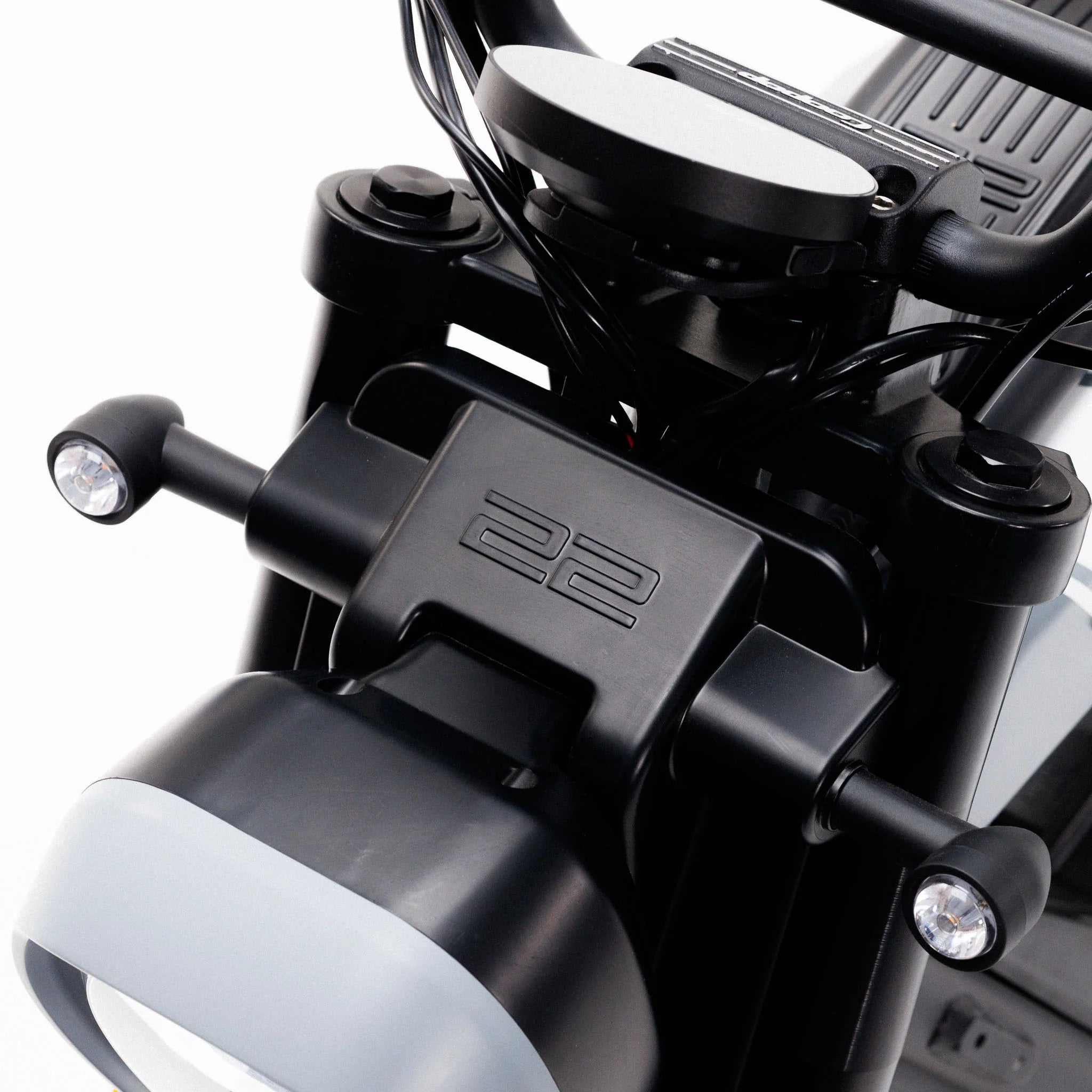 Nahaufnahme des Coopop Scrambler – eines 45 km/h schnellen Elektrorollers und E-Scooters von Coopop mit einem Motor mit einer Spitzenleistung von 8 kW, der sein elegantes Design in Schwarz und Silber im Scrambler-Stil, den Lenker, den Scheinwerfer und ein Bauteil mit der Prägung „22“ zeigt.