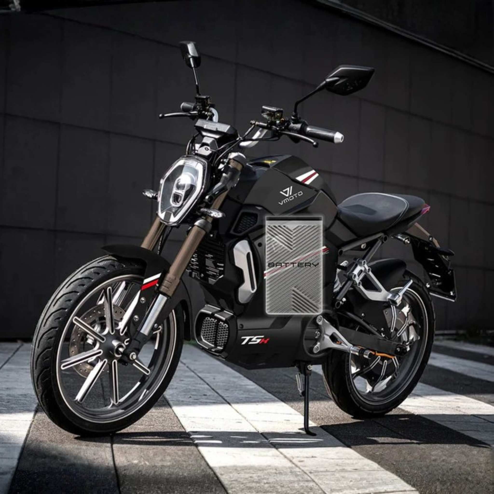 Der VMOTO TSX 72V Elektroroller im modernen Motorrad-Design von VMOTO steht auf gestreiftem Asphalt in urbaner Umgebung. Das schwarze Modell mit markantem Akku überzeugt durch innovative, sportlich-elegante Linienführung und 45 km/h Leistung.