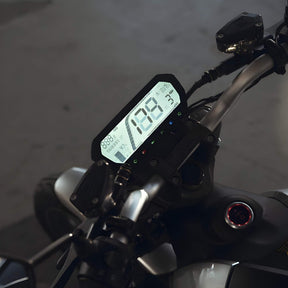 Die Nahaufnahme des Armaturenbretts des VMOTO TSX 72V Elektrorollers zeigt einen digitalen Tacho bei 188, Blinker und Lenkerbedienelemente bei schlechten Lichtverhältnissen und unterstreicht das moderne Motorrad-Design und die leistungsstarke 72V Technologie.