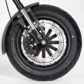 Nahaufnahme des Vorderrads eines schwarzen Mangosteen M1P Citycoco E-Chopper (Modell 26) Elektrorollers, bei der der Reifen, die Bremsscheibe und die Federgabel vor einem schlichten weißen Hintergrund hervorgehoben werden.
