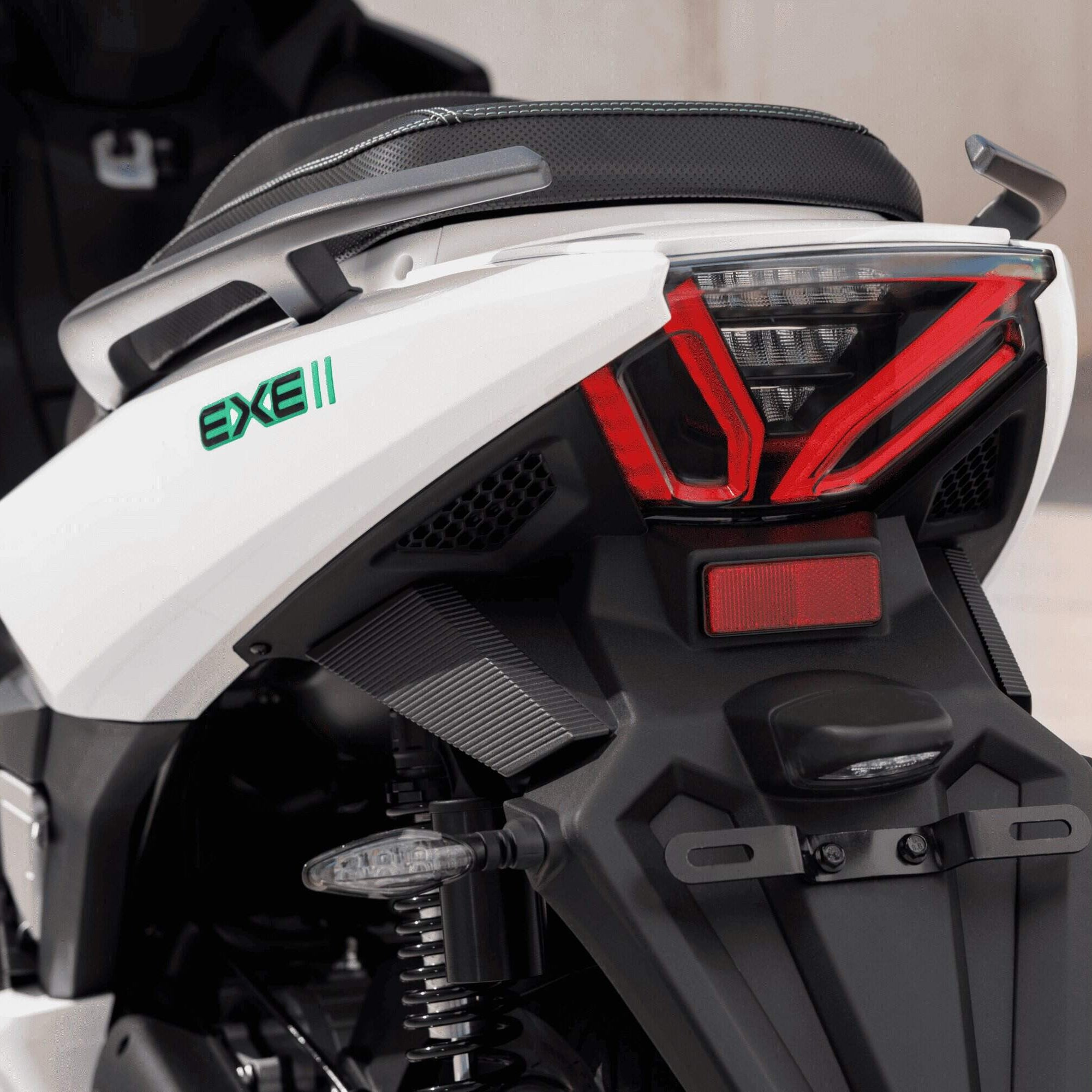 Nahaufnahme des Hecks des NERVA EXE II 2025 | B196 Elektrorollers mit Rücklicht, Blinker und Sitz. Der weiße Roller unterstreicht die moderne Elektromobilität mit bis zu 170 km Eco-Reichweite vor einem unscharfen Außenhintergrund.