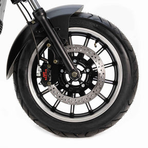Nahaufnahme eines NEU - E-Choppers: CityTwister 6.0 MAX DUO-Vorderrad mit schwarzem Reifen, silberner Leichtmetallfelge, Scheibenbremse mit REVEX-Bremssattel und Federgabel für den 4000W-Motor. Einfarbig weißer Hintergrund. Marke: City Twister.
