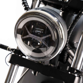 Nahaufnahme des City Twister NEU - E-Choppers: CityTwister 6.0 MAX DUO's runder LED-Scheinwerfer mit klarer Linse und schwarzem Gehäuse, montiert zwischen Gabelrohren, mit detaillierter Verkabelung, angetrieben von einem robusten 4000W Motor. Modell 2026.