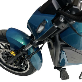 Schräge Nahaufnahme des Vorderrads und des Kotflügels des City Twister E-Chopper Elektro Motorrad: CityTwister 6.0 PRO, mit Scheibenbremse, Federung und Fußraste auf einem blauen Gehäuse. Ausgestattet mit einem leistungsstarken 5000-Watt-Motor; Höchstgeschwindigkeit 110 km/h.