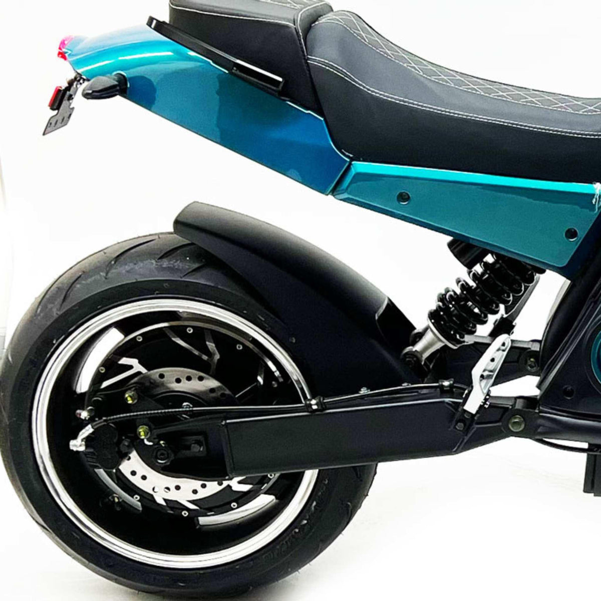 Nahaufnahme des City Twister E-Chopper Elektro Motorrad: CityTwister 6.0 PRO 110 km/h, mit schwarzem Sitz, tealfarbener Karosserie, großem Hinterradreifen, Scheibenbremse, Schraubenfederung und Schwinge vor weißem Hintergrund.