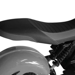 Nahaufnahme eines „City Twister CityTwister 6.0 PREMIUM DUO 45 km/h E-Chopper“ von Das Original, mit Fokus auf den schwarzen gepolsterten Sitz, die aufwendigen Nähte, den Hinterradkotflügel und einen Teil des Federungssystems in einem Graustufenbild – eine stilvolle Hommage an die zeitgenössische Elektromobilität.