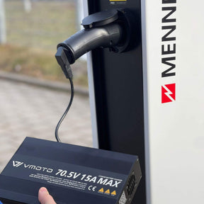 Eine Person benutzt den VMOTO TYP2 Adapter für Schuko Stecker - Die zuverlässige Ladelösung für dein Elektro Motorrad, E-Chopper, E-Roller, E-Scooter uvm.! 🔌⚡ zum Anschluss an eine MENNEKES Ladesäule für Elektrofahrzeuge laden.