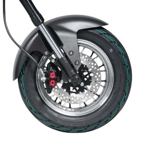 Nahaufnahme eines Mangosteen E-Chopper Mangosteen M1P-Rads mit Scheibenbremse, Metallspeichen, schwarzem Schutzblech und grüner Akzentlinie auf dem Reifen - die Markenzeichen dieses Premiummodells mit 30 Ah Akku (45 km/h), das sowohl elegant als auch praktisch ist.