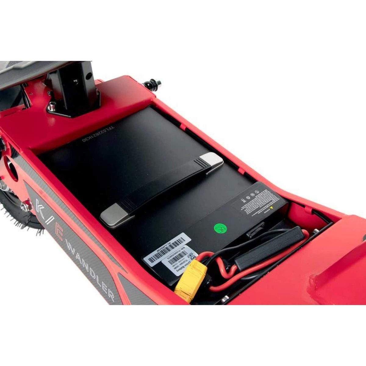 Nahaufnahme eines schwarzen Batteriefachs im Inneren eines roten Wandler L/E 20 km/h E-Rollers mit Sitz und Straßenzulassung / E-Scooter von Wandler, der den Akku mit einem Griff, einem gelben Stecker sowie gut sichtbaren Etiketten und Barcodes zeigt – ein Beispiel für innovative Lösungen im Bereich der elektrischen Nahmobilität für städtische Umgebungen.