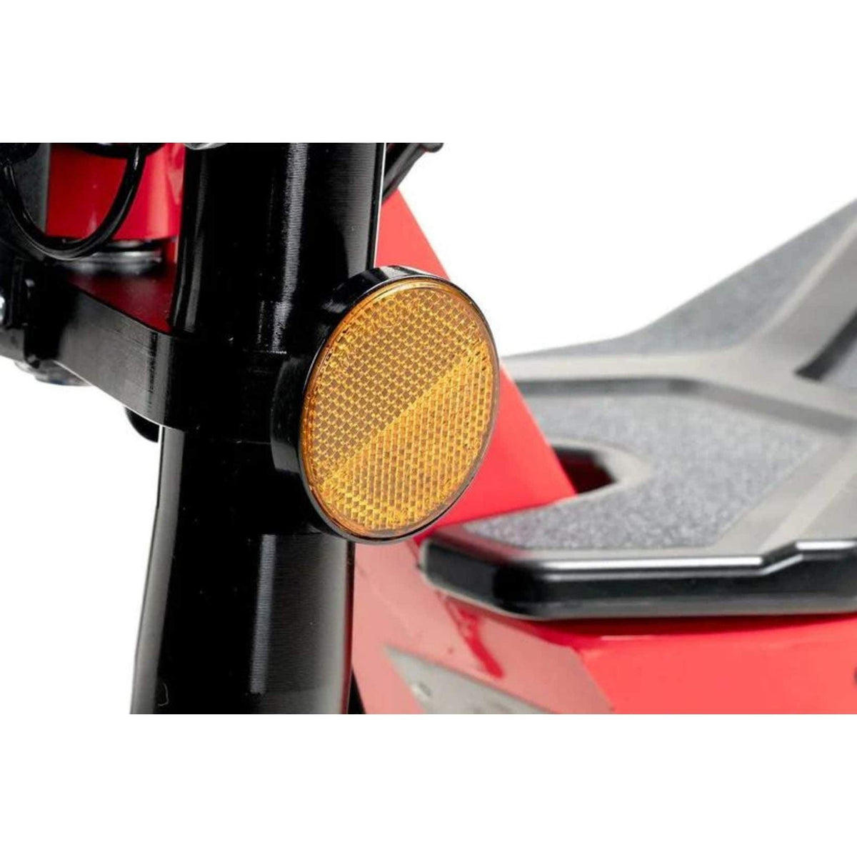 Nahaufnahme eines runden gelben Reflektors, der an der schwarzen Gabel eines roten Wandler K/E 45 km/h E-Rollers / E-Scooters mit Sitz und Straßenzulassung befestigt ist; im Hintergrund sind ein Teil der Fußstütze und des Rahmens zu sehen.