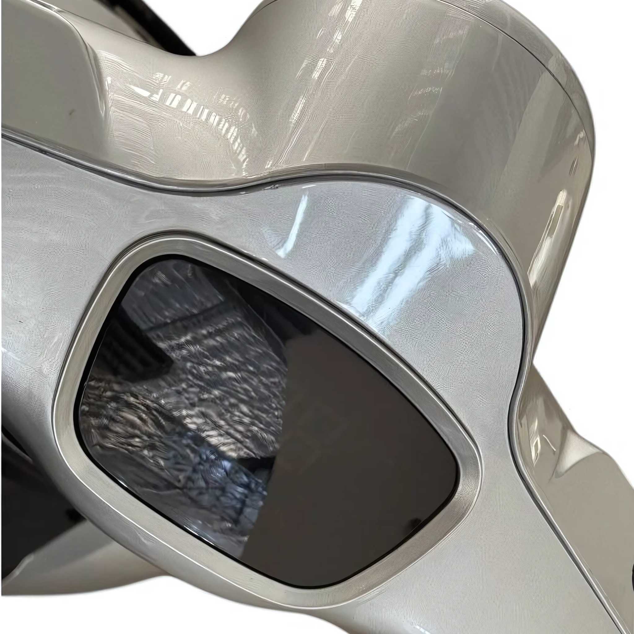 Nahaufnahme des eleganten, silber-schwarz glänzenden Trinity ATLAS Elektromobils mit einem getönten, eckigen Fenster, in dem sich eine gitterartige Decke spiegelt. Dieser moderne 4-Rad-Seniorenroller verfügt über einen austauschbaren Akku und eine Reichweite von bis zu 144 km, bereit für den Straßenverkehr.
