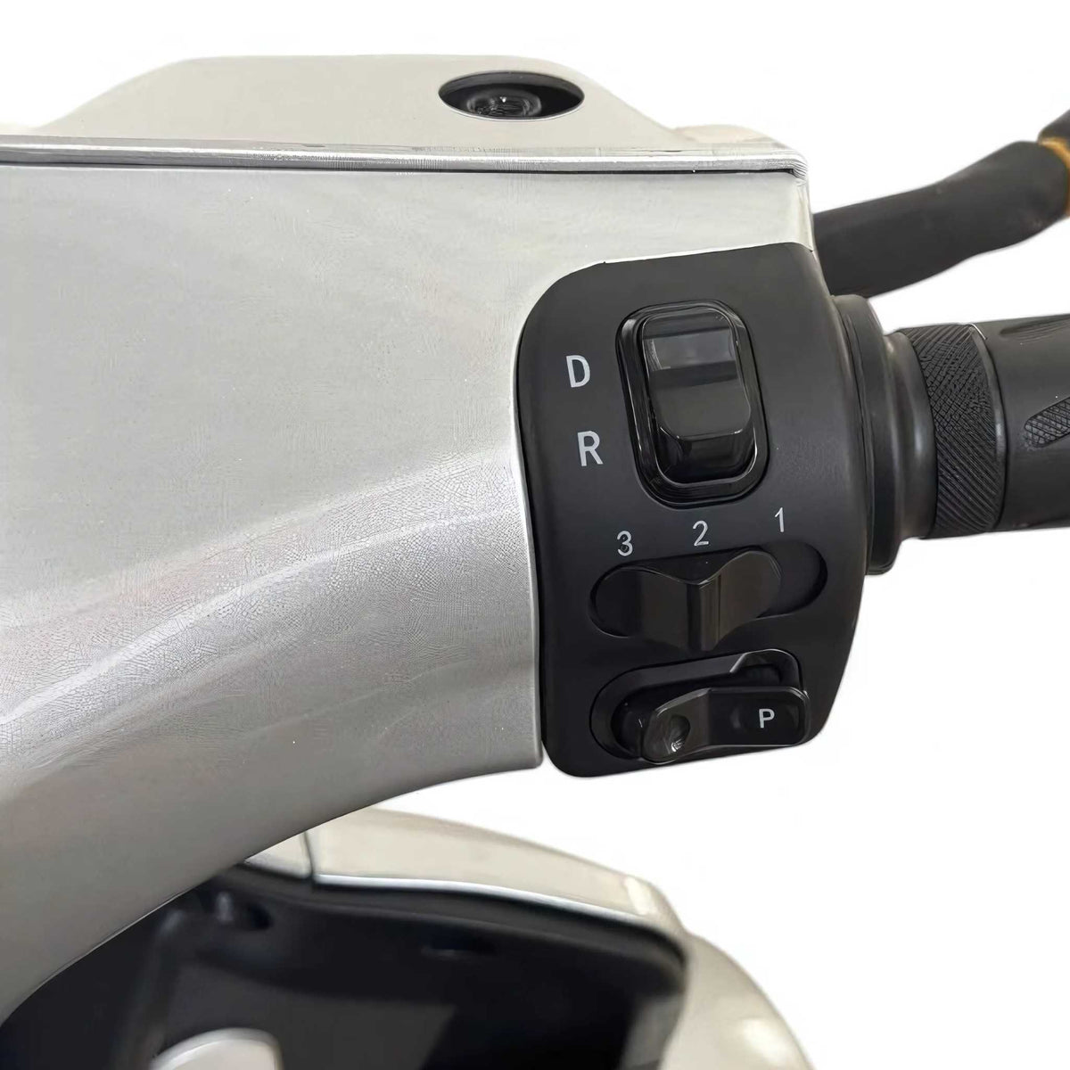 Nahaufnahme des Lenkers des Elektromobils Trinity ATLAS 1800 mit einem schwarzen Bedienfeld, auf dem die Schalter mit den Bezeichnungen D, R, 1, 2, 3 und P zu sehen sind. Das Bedienfeld ist auf einer metallisch-silbernen Oberfläche angebracht und zeigt die für die Seniorenmobile von Trinity für die elektrische Mobilität typischen, intuitiven Bedienelemente.