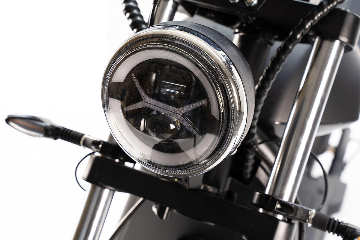 Nahaufnahme des City Twister NEU - E-Choppers: Der runde LED-Scheinwerfer, die Gabelrohre und die Blinker des CityTwister 6.0 MAX DUO, die den leistungsstarken 4000-Watt-Motor hervorheben; Modell 2026 auf weißem Hintergrund.