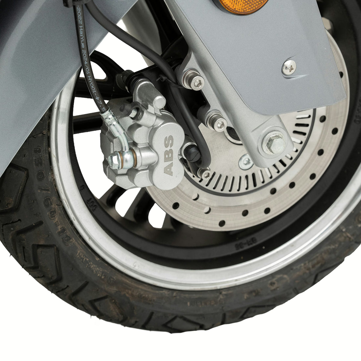 Nahaufnahme des Vorderrads eines Trinity Jupiter GT 300 Elektrorollers mit Scheibenbremse und ABS-Einheit. Das robuste Reifenprofil und die detailreich gestalteten Bremskomponenten aus Metall unterstreichen das fortschrittliche Design dieses Trinity-E-Roller-Modells aus dem Jahr 2026.