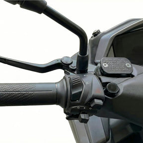 Nahaufnahme des Lenkers des Trinity Jupiter GT 300 mit Gasgriff, Bedienschaltern, Bremshebel, Rückspiegelhalterung und graviertem Warnhinweis; einfarbiger Hintergrund. E-Roller | 125 km/h | 280 km Reichweite | Modell 2026.