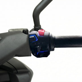 Nahaufnahme des Trinity Jupiter GT 300 E-Roller (2026) Lenkergriffs von Trinity, der einen strukturierten Gummigriff, ein Bedienfeld mit Tasten und einen Gangwahlschalter (1-3, R) vor einem schlichten weißen Hintergrund zeigt.