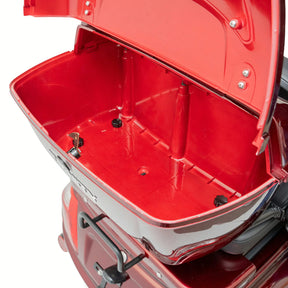 Offenes, rotes Staufach an der Rückseite eines TRINITY Atlas Premium 1800 | Seniorenmobil 25 km/h von Trinity, das den leeren Innenraum mit sichtbaren Scharnieren und Verriegelungsmechanismen zeigt. Das Fach ist über dem Hinterrad angebracht und bietet praktischen Stauraum für mehr Komfort und Mobilität.