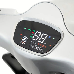 Nahaufnahme des Armaturenbretts eines TRINITY Atlas Premium 1800 Seniorenmobils (25 km/h) von Trinity, auf dem die Geschwindigkeit in km/h, der Ladezustand der Batterie sowie Kontrollleuchten für Betriebsbereitschaft, Scheinwerfer und verschiedene Warnmeldungen angezeigt werden. Die hellen, farbenfrohen digitalen Symbole auf dem Display sorgen dafür, dass jede Fahrt mit diesem Elektromobil übersichtlich und komfortabel ist.