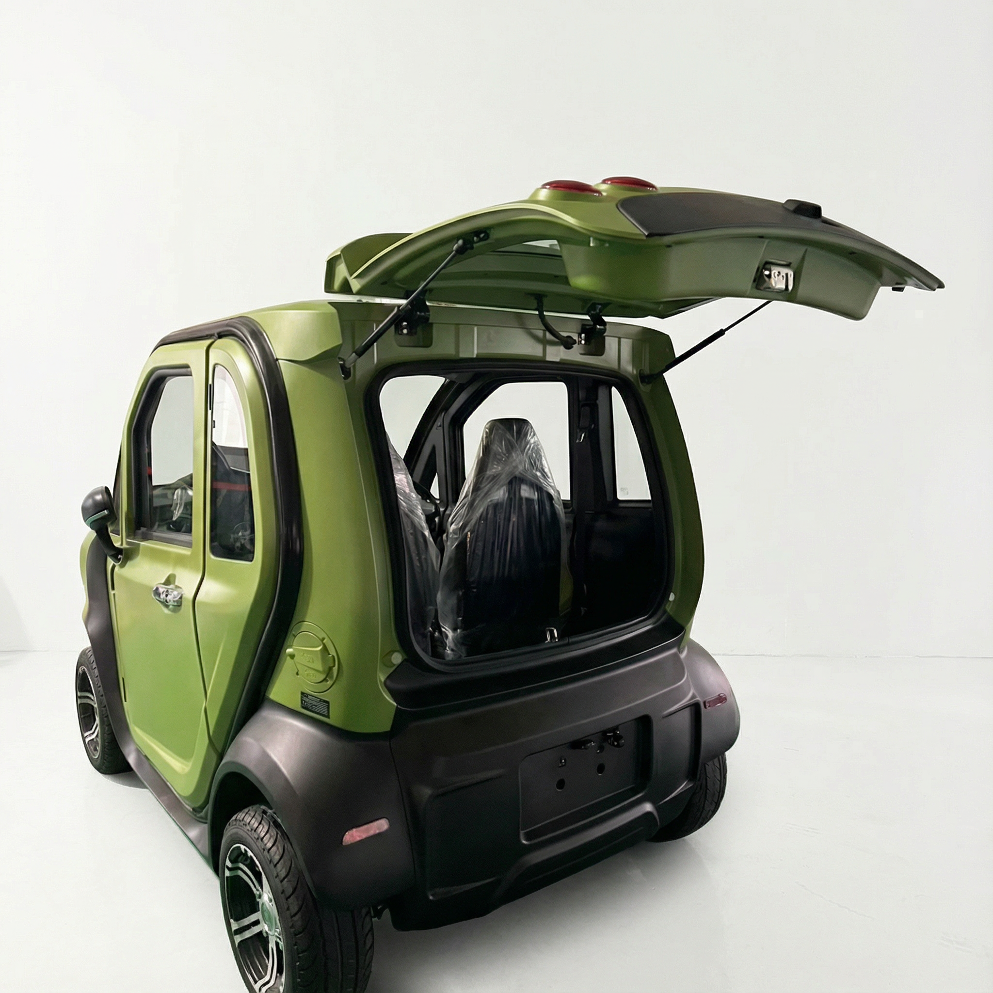 Ein kleiner, grüner City Twister Luqi EV300 Pro Kabinenroller (Facelift Modell 2026, 45 km/h) steht mit geöffneter Heckklappe in einem weißen Studio und zeigt zwei mit Schutzfolie überzogene Sitze.