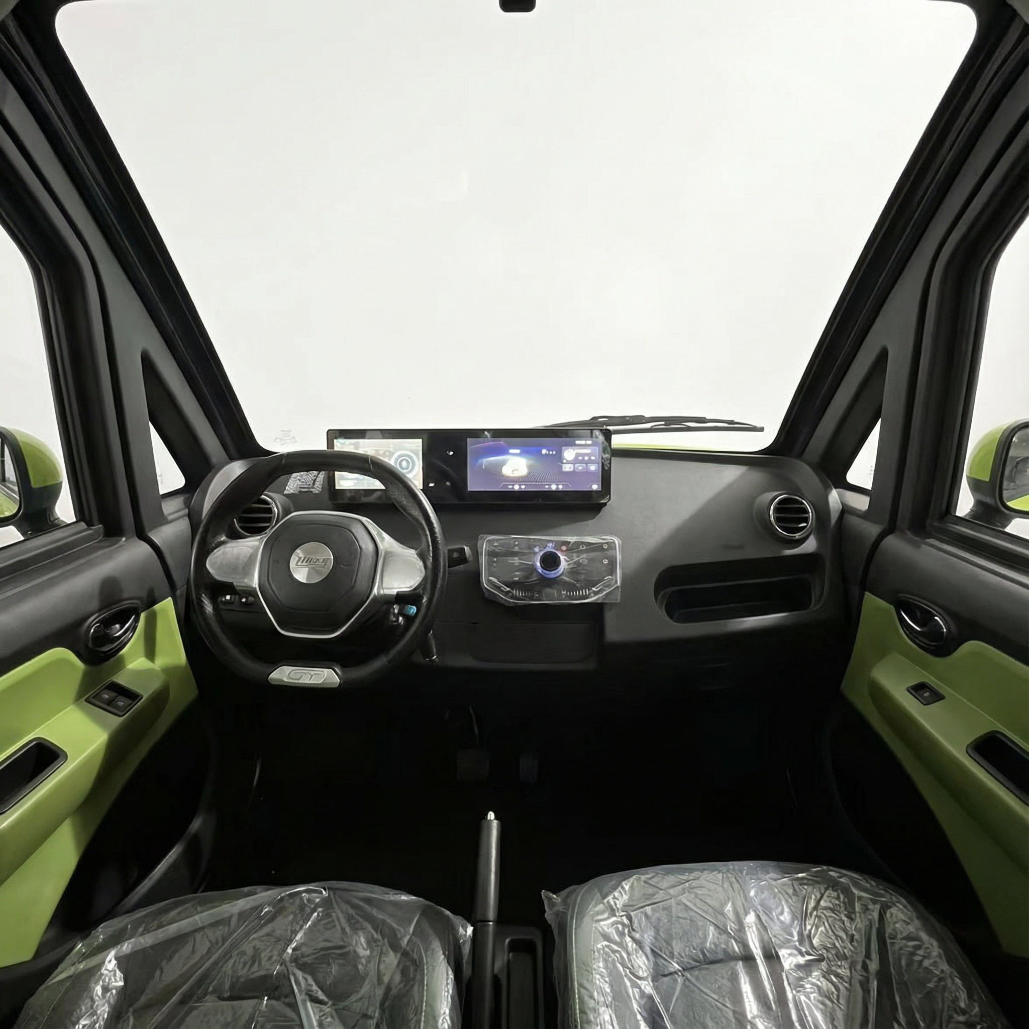 Innenraum des City Twister Luqi EV300 Pro Kabinenroller Facelift 2026 mit schwarzen und lindgrünen Akzenten, kunststoffverkleideten Sitzen, Touchscreen-Armaturenbrett, Lenkrad und Seitenspiegeln vor einem schlichten weißen Hintergrund.