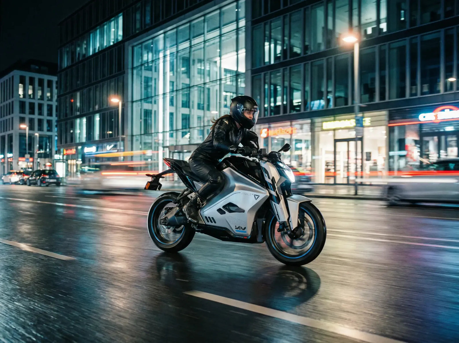 Person fährt nachts auf einem E-Motorrad durch eine Stadt