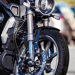 Nahaufnahme von Vorderrad und Scheinwerfer des VMOTO TC 72V Elektrorollers im Café-Racer-Design (45 km/h) von VMOTO, mit Scheibenbremse, Federgabel und Karosseriedetails vor unscharfem Hintergrund.