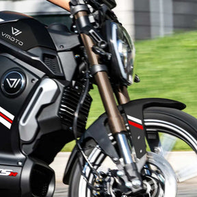 Nahaufnahme einer Person, die den VMOTO TSX 72V fährt, einen leistungsstarken 45 km/h Elektroroller im Motorrad-Design. Das Bild zeigt den schwarz-silbernen Roller mit roten und weißen Streifen, Vorderrad, Scheinwerfer und einen Teil des Arms des Fahrers.